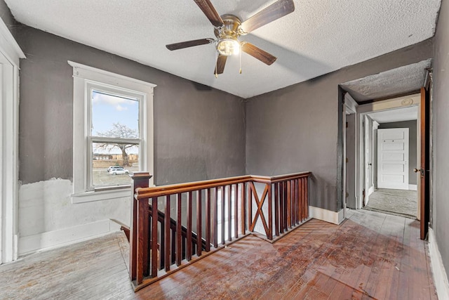 107 6th Ave SE, Waseca, MN 56093 - hall featuring a textured ceiling, an upstairs landing, and hardwood / wood-style flooring