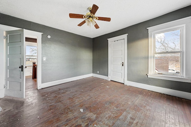 107 6th Ave SE, Waseca, MN 56093 - spare room with wood-type flooring, a textured ceiling, baseboards, and ceiling fan