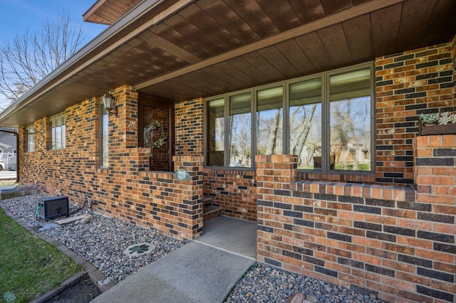 doorway to property with central air condition unit and brick siding