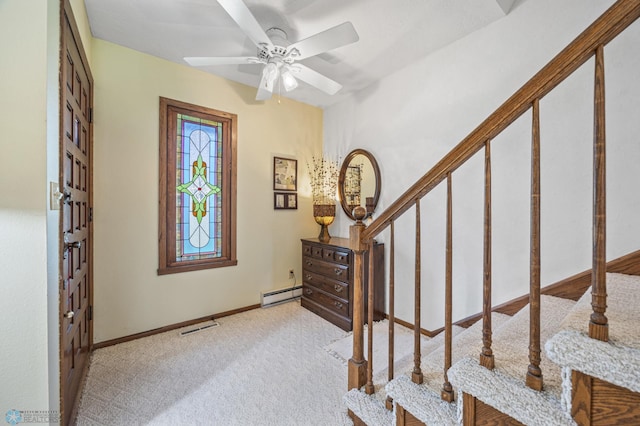 carpeted entrance foyer with visible vents, a ceiling fan, stairs, baseboards, and a baseboard radiator