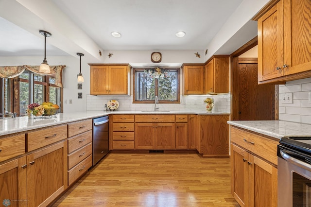 kitchen featuring a sink, tasteful backsplash, stainless steel appliances, and light wood-style flooring