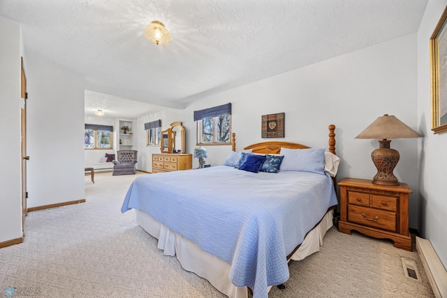bedroom with carpet flooring, a textured ceiling, baseboards, and visible vents