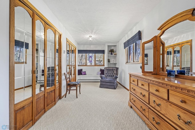 sitting room featuring french doors, a textured ceiling, baseboard heating, baseboards, and light carpet