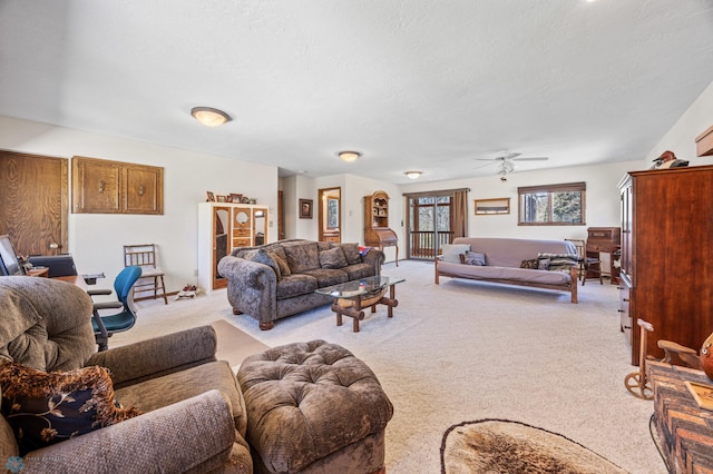 living room featuring light colored carpet, a textured ceiling, and ceiling fan