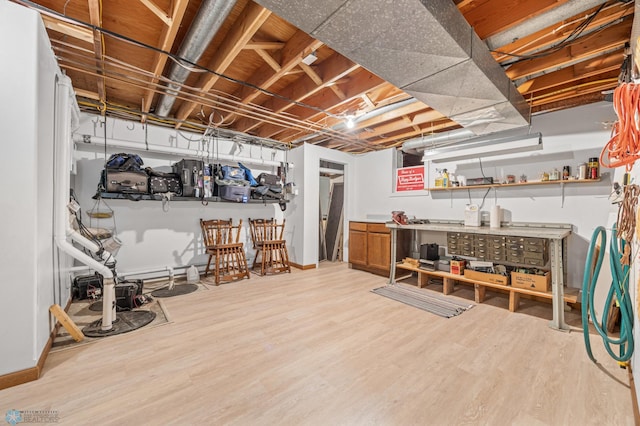 unfinished basement with baseboards and wood finished floors