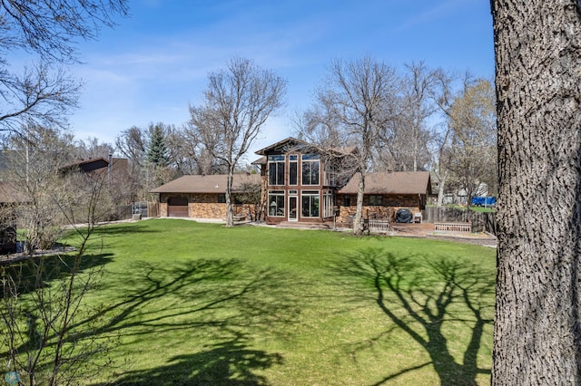 rear view of property featuring a garage and a yard