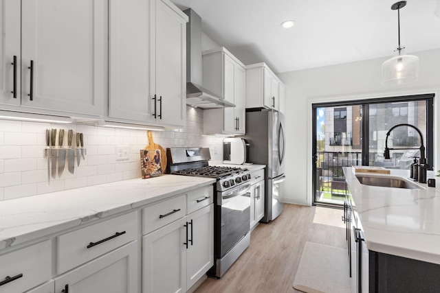 kitchen with a sink, appliances with stainless steel finishes, tasteful backsplash, and light wood-style floors