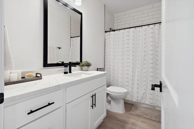 bathroom with vanity, a shower with curtain, toilet, and wood finished floors