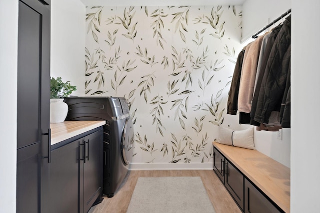 washroom featuring baseboards, light wood finished floors, cabinet space, and wallpapered walls