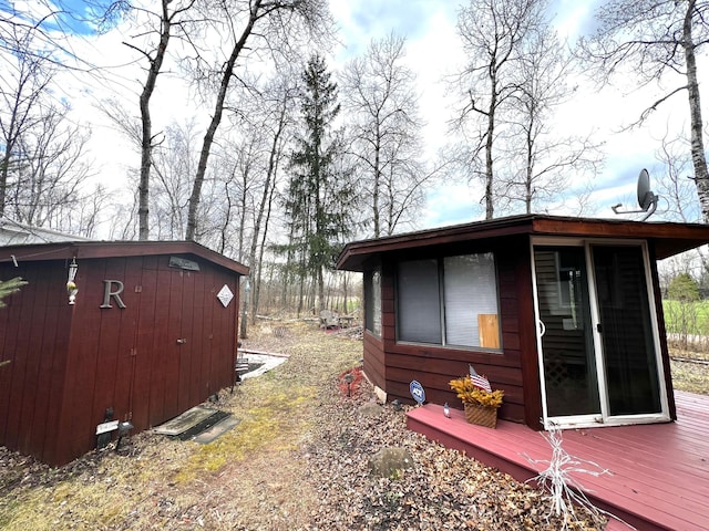 view of home's exterior featuring an outdoor structure and a deck