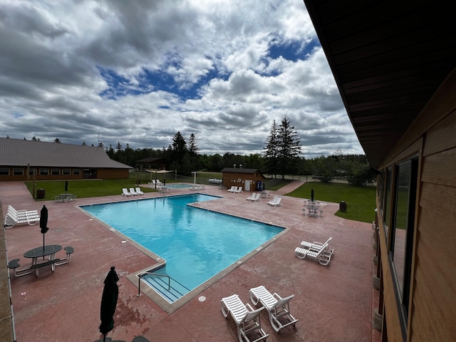 community pool featuring a patio area and a yard