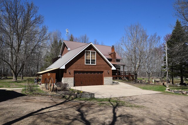 30472 Lightning Pass Unit 1, Turtle Creek Twp, MN 56443 - view of property exterior with driveway, a chimney, metal roof, an attached garage, and stone siding