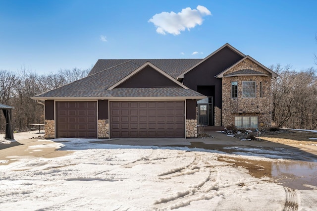 view of front of property featuring an attached garage, a shingled roof, and stone siding