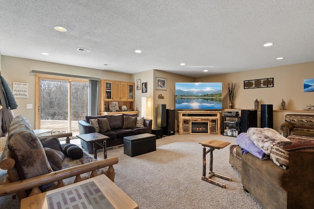 carpeted living area featuring a glass covered fireplace, recessed lighting, a textured ceiling, and visible vents