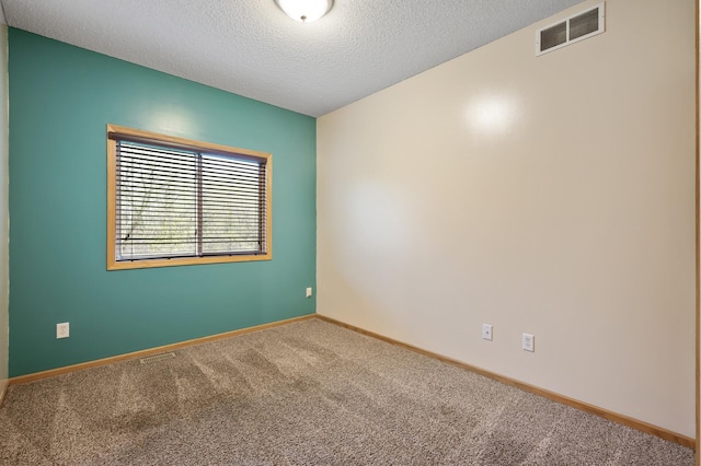 unfurnished room featuring visible vents, a textured ceiling, carpet, and baseboards