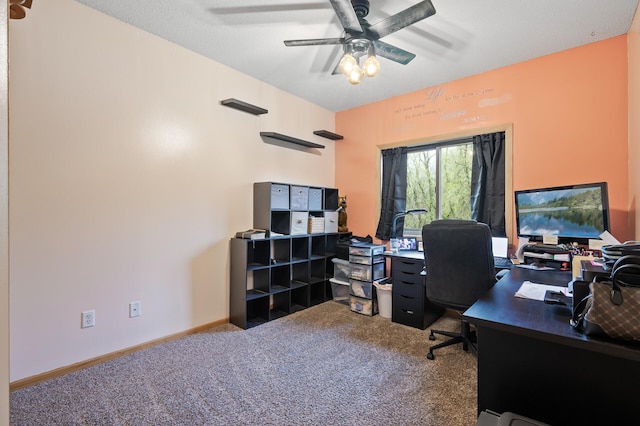 carpeted office with a ceiling fan