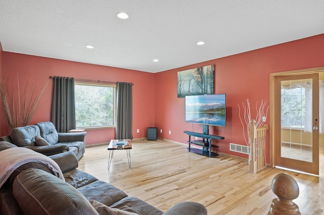 living room with baseboards, recessed lighting, wood finished floors, and visible vents