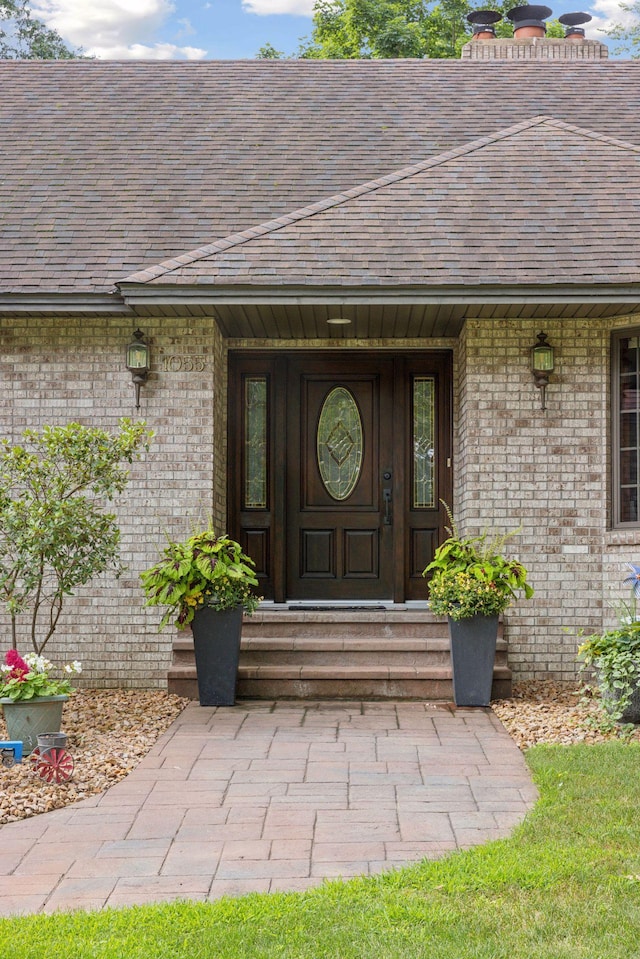 1055 Nelson Dr, Shoreview, MN 55126 - doorway to property featuring brick siding, covered porch, and roof with shingles