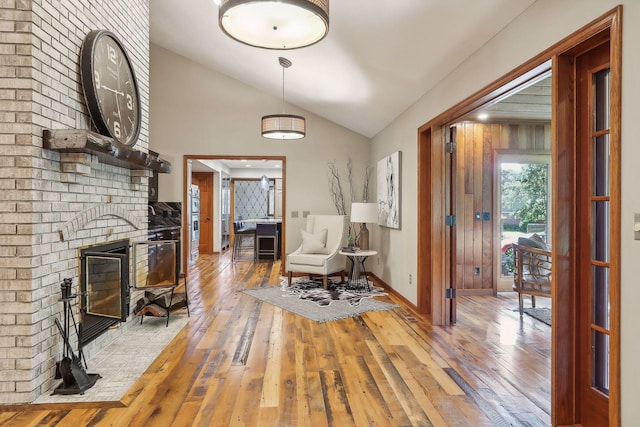 1055 Nelson Dr, Shoreview, MN 55126 - entryway featuring lofted ceiling, wood-type flooring, a brick fireplace, and baseboards