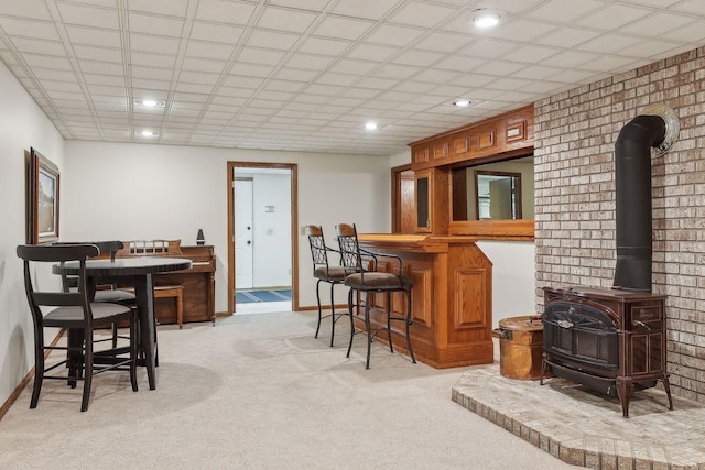 1055 Nelson Dr, Shoreview, MN 55126 - indoor dry bar featuring a wood stove, light colored carpet, recessed lighting, and baseboards
