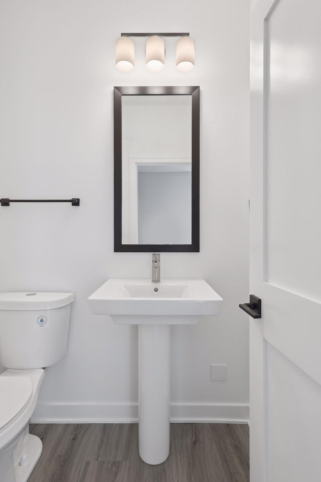 bathroom featuring baseboards, toilet, and wood finished floors