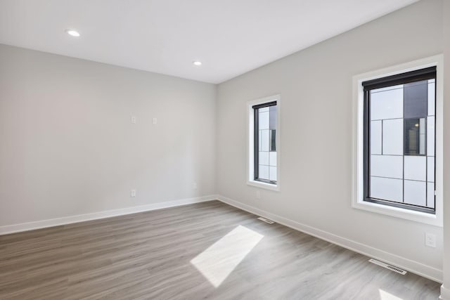 unfurnished room with visible vents, baseboards, and wood finished floors