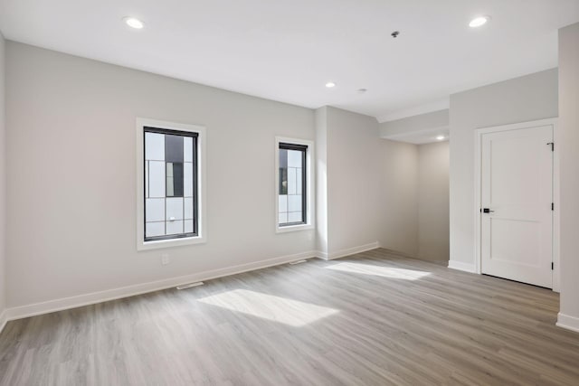 spare room with baseboards, recessed lighting, and light wood-style flooring