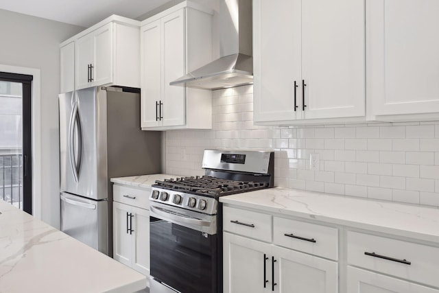 kitchen with white cabinets, backsplash, stainless steel appliances, and wall chimney exhaust hood