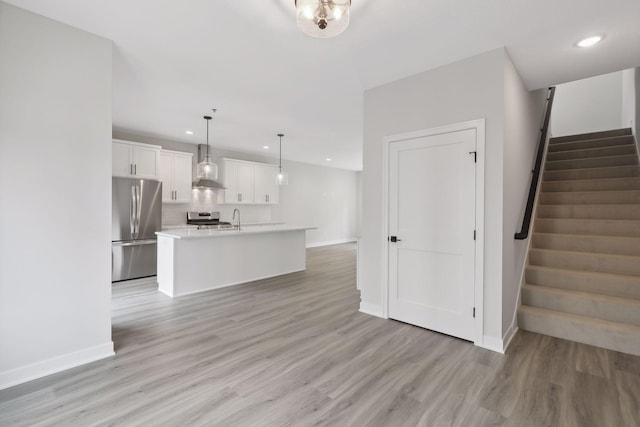 unfurnished living room featuring baseboards, recessed lighting, and stairs