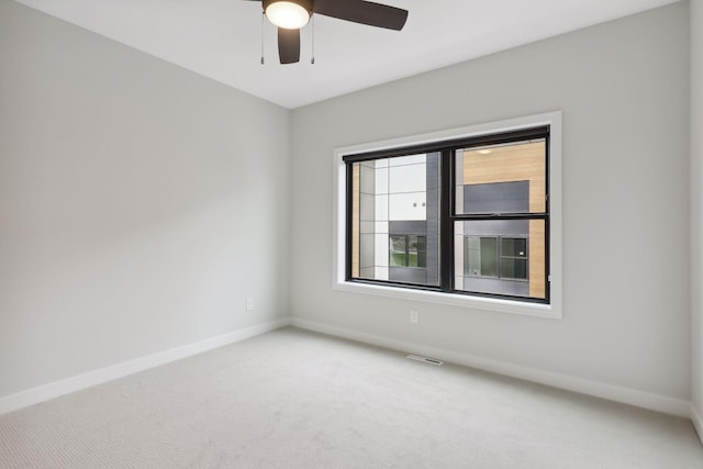 unfurnished room featuring baseboards, ceiling fan, and light carpet