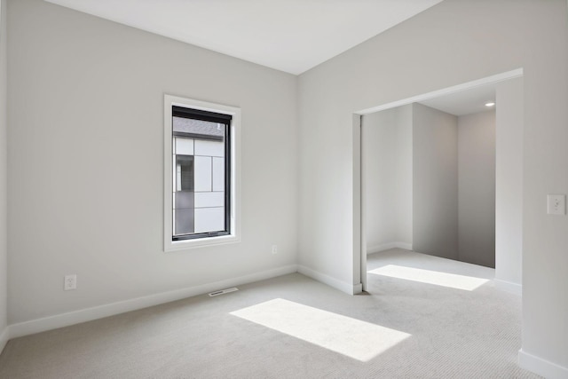 carpeted empty room with baseboards and visible vents