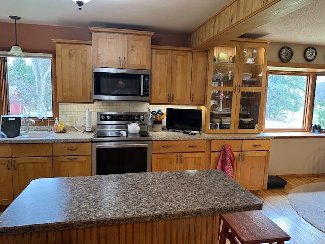 9700 Aspen Ave NW, Bemidji, MN 56601 - kitchen with plenty of natural light, light wood finished floors, backsplash, and stainless steel appliances