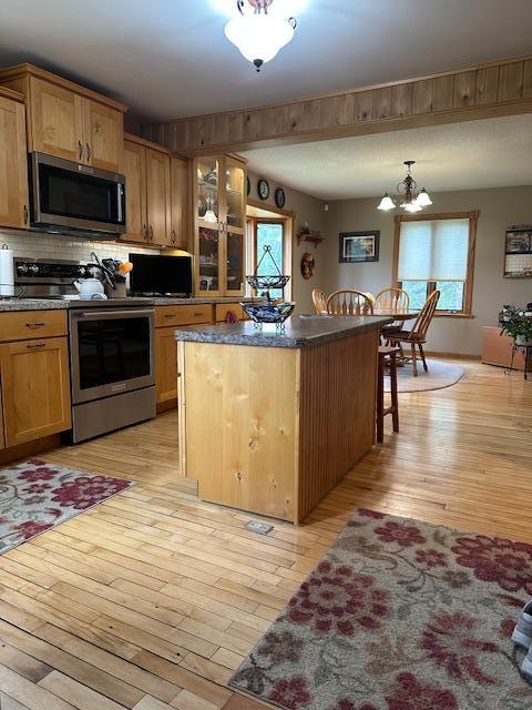 9700 Aspen Ave NW, Bemidji, MN 56601 - kitchen with a center island, light wood finished floors, a healthy amount of sunlight, and stainless steel appliances