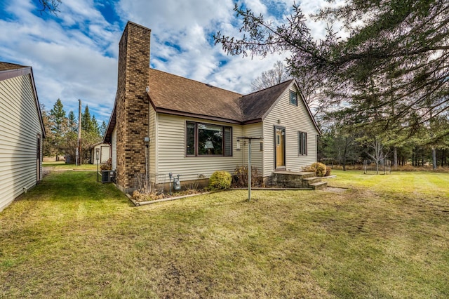 9700 Aspen Ave NW, Bemidji, MN 56601 - view of property exterior featuring roof with shingles, central air condition unit, a chimney, and a lawn