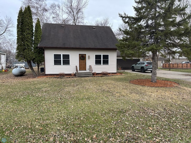 new england style home with concrete driveway, a garage, and a front lawn