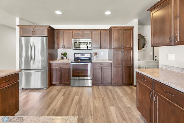 kitchen featuring appliances with stainless steel finishes, light wood-type flooring, light countertops, and recessed lighting