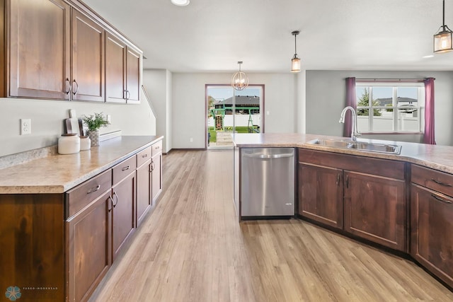 kitchen featuring dishwasher, a sink, light wood finished floors, and healthy amount of natural light