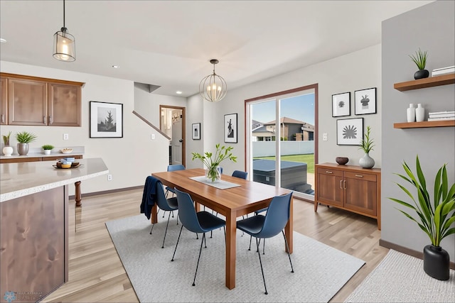 dining space featuring light wood-type flooring, baseboards, recessed lighting, and a chandelier