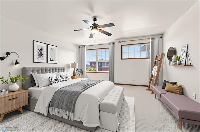 bedroom with light carpet, a ceiling fan, and baseboards