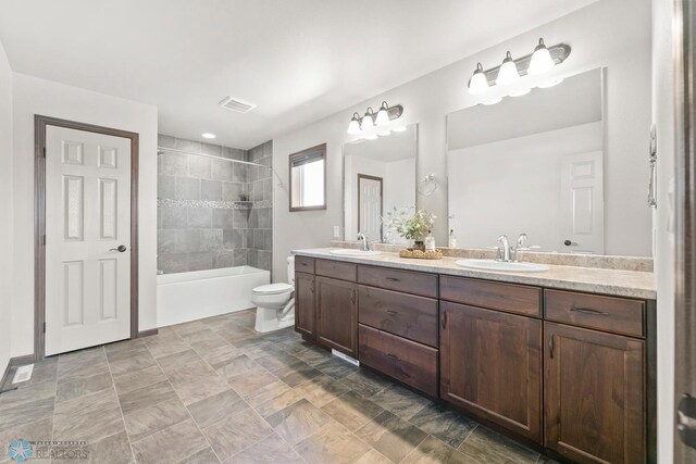 full bathroom with double vanity, toilet, and bathing tub / shower combination