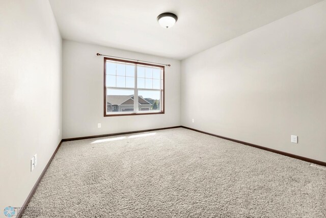 unfurnished room with carpet floors and baseboards