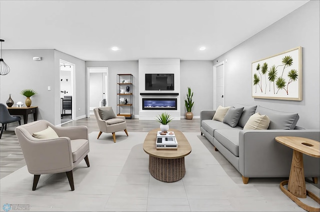 living area featuring recessed lighting, baseboards, and a glass covered fireplace
