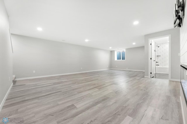 basement with light wood-style floors, recessed lighting, and baseboards