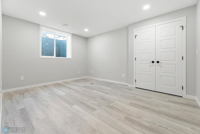 basement featuring light wood finished floors, baseboards, and recessed lighting