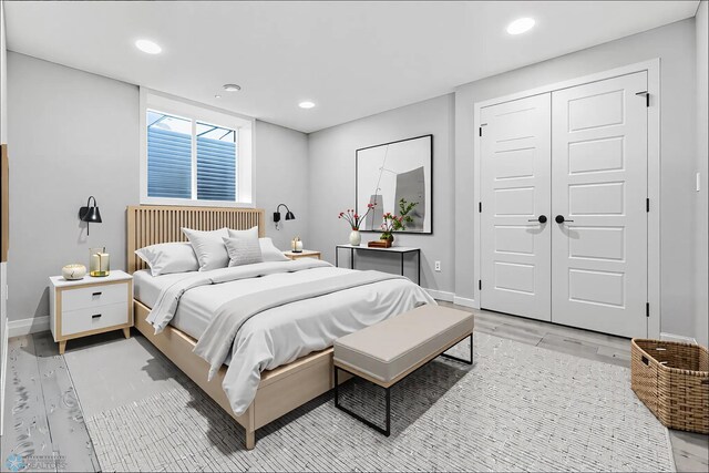 bedroom featuring baseboards, light wood-type flooring, recessed lighting, and a closet