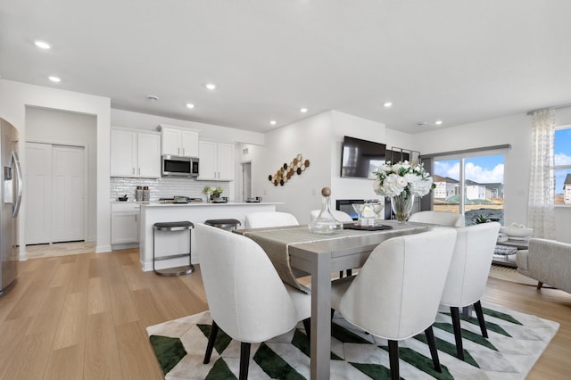 dining space with light wood-style floors and recessed lighting