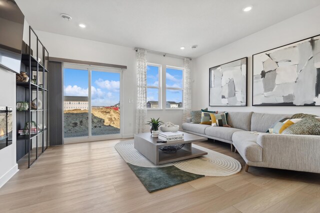 living room featuring light wood-type flooring, plenty of natural light, and recessed lighting