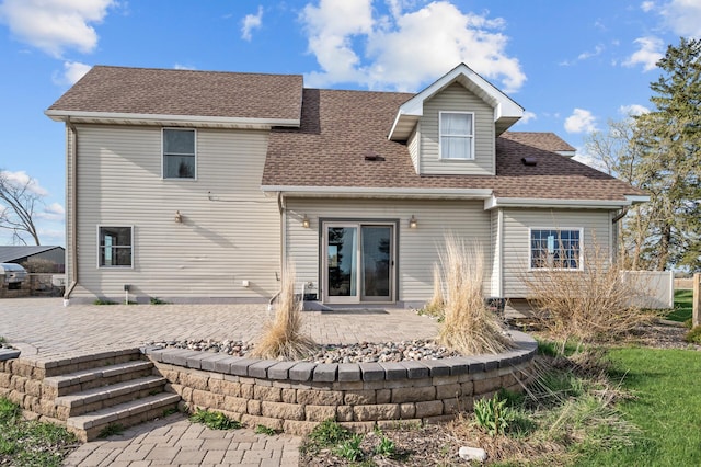 rear view of property with a patio and roof with shingles