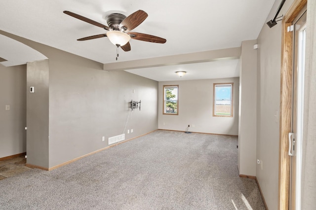 empty room with ceiling fan, visible vents, baseboards, and carpet