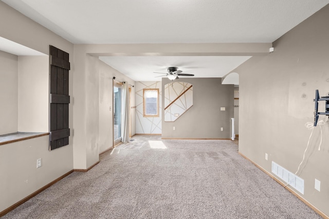 unfurnished living room featuring carpet floors, ceiling fan, baseboards, and visible vents
